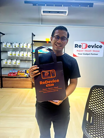 Customer in glasses holding a ReDevice bag in the store